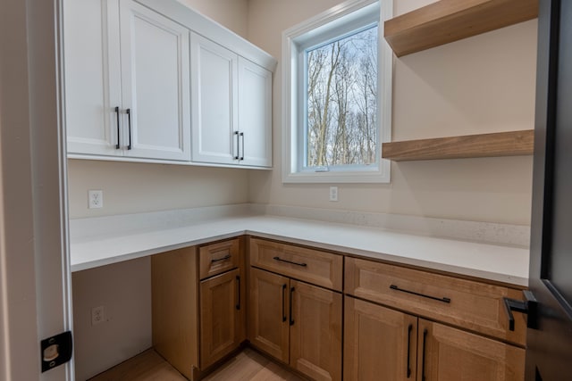 kitchen with light countertops, white cabinets, brown cabinets, and open shelves