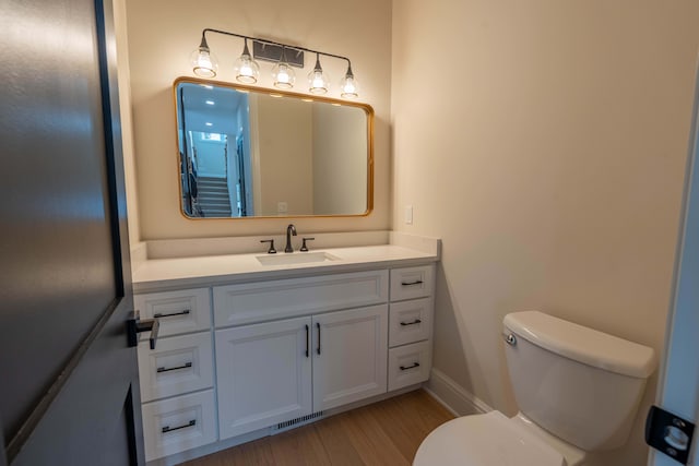 bathroom with visible vents, toilet, wood finished floors, and vanity