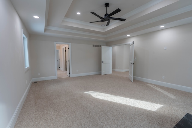 unfurnished bedroom with visible vents, baseboards, light colored carpet, recessed lighting, and a raised ceiling