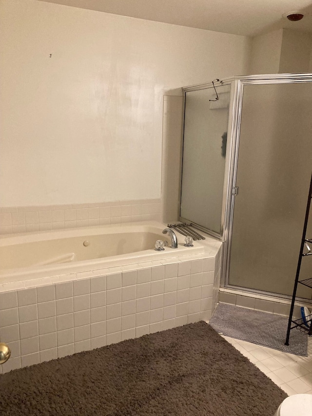 full bathroom with a shower stall, a bath, and tile patterned floors