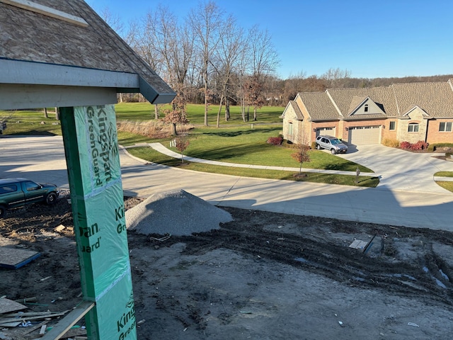 view of yard featuring concrete driveway and an attached garage