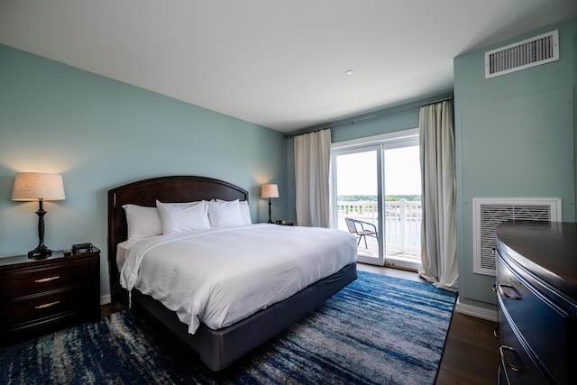 bedroom with access to exterior, dark wood-style flooring, visible vents, and baseboards