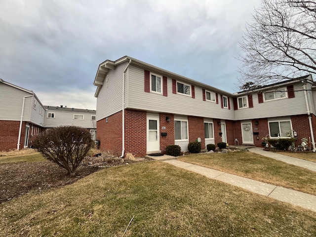 view of front of property with brick siding and a front yard