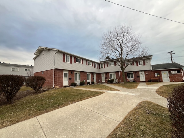 view of front of home with brick siding and a front lawn