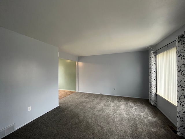 carpeted empty room featuring plenty of natural light and visible vents