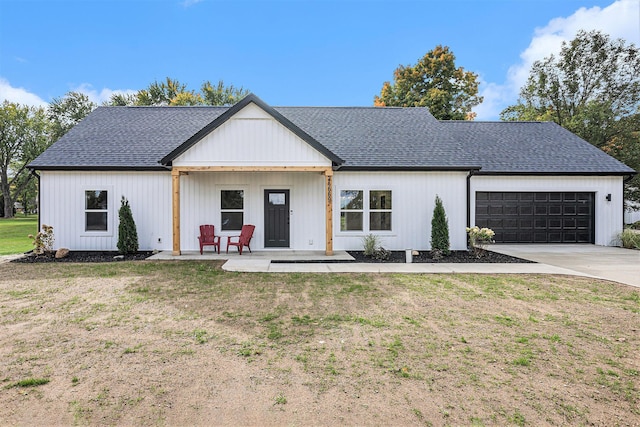 modern farmhouse style home with a garage, a front yard, concrete driveway, and roof with shingles