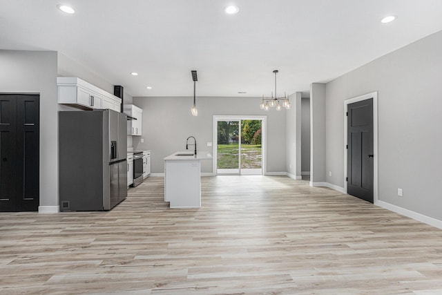 kitchen with white cabinets, appliances with stainless steel finishes, light countertops, a sink, and recessed lighting