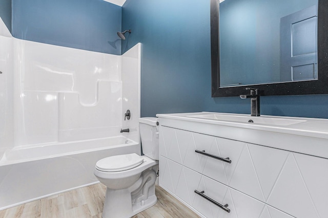 bathroom featuring  shower combination, vanity, wood finished floors, and toilet