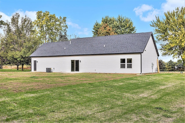 back of property with roof with shingles, a lawn, and cooling unit