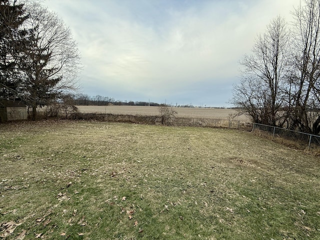 view of yard featuring a rural view and fence