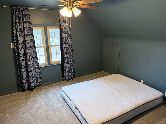 bedroom featuring a ceiling fan, vaulted ceiling, and carpet flooring