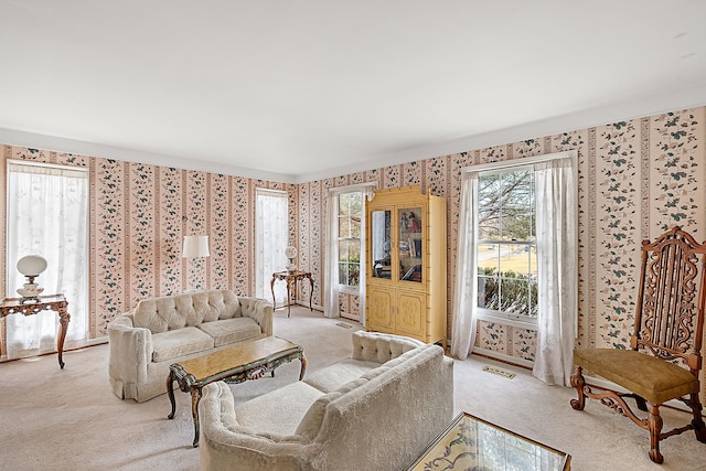 carpeted living room with wallpapered walls and visible vents