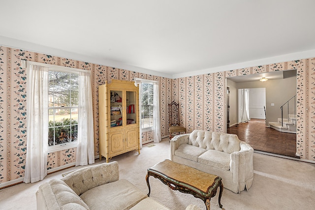 living area with light carpet, stairway, visible vents, and wallpapered walls