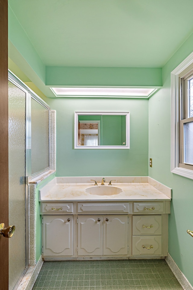 bathroom featuring a shower stall, vanity, and baseboards