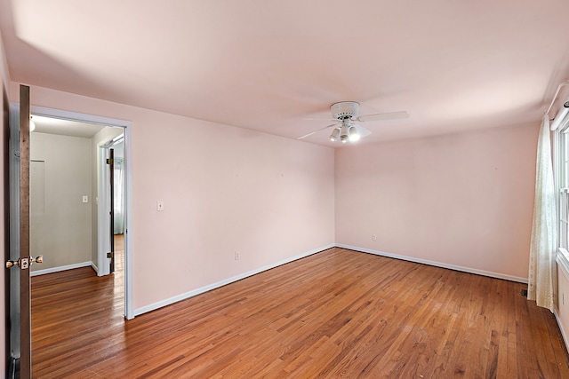 empty room featuring light wood-style floors, ceiling fan, and baseboards