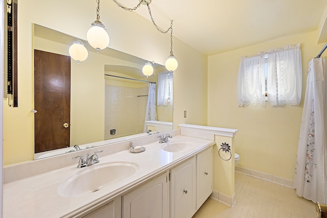 bathroom with toilet, plenty of natural light, baseboards, and a sink