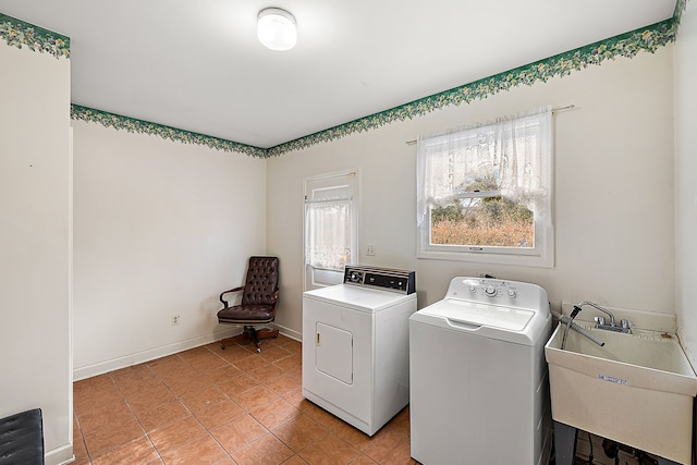 laundry room with light tile patterned floors, washing machine and dryer, a sink, laundry area, and baseboards