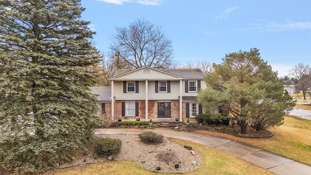 view of front of property featuring a front yard, crawl space, brick siding, and driveway