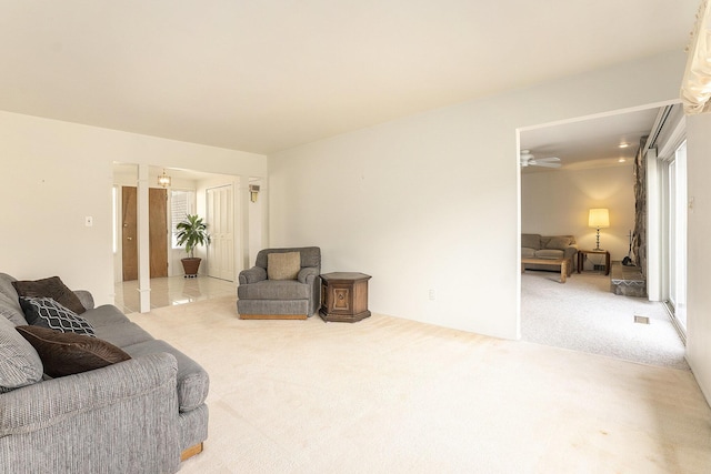 living area featuring a ceiling fan and carpet