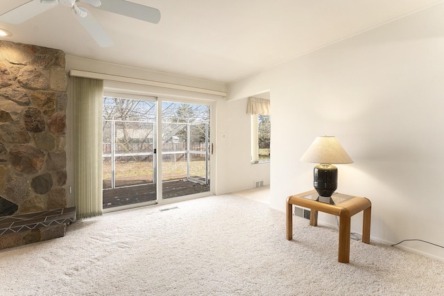 sitting room with a ceiling fan, carpet, and visible vents