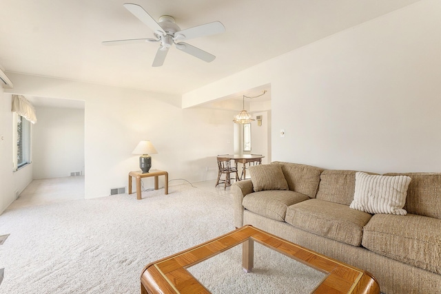 living room with carpet floors, visible vents, and ceiling fan