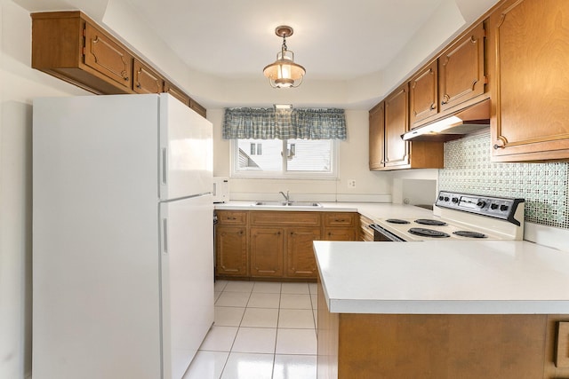 kitchen featuring brown cabinets, freestanding refrigerator, a sink, range with electric cooktop, and under cabinet range hood