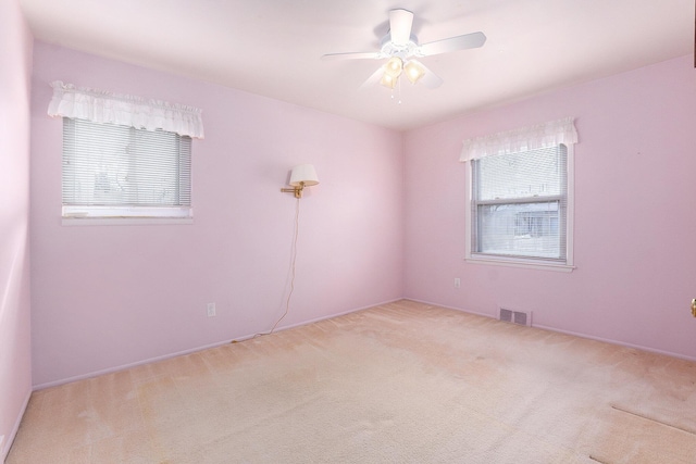 carpeted empty room with a ceiling fan and visible vents