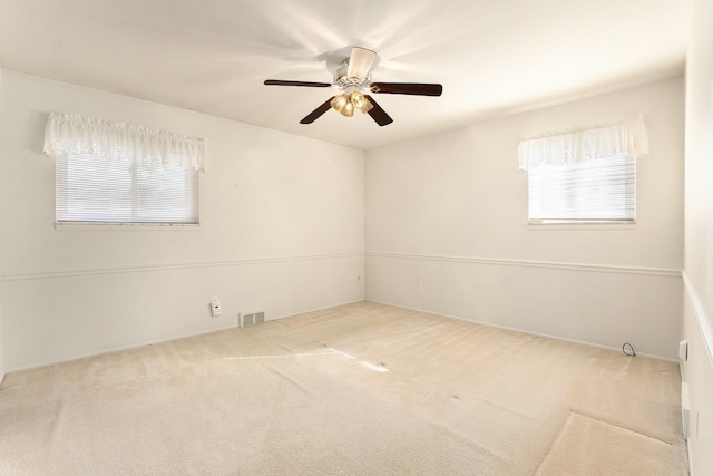 unfurnished room featuring ceiling fan, visible vents, and carpet flooring