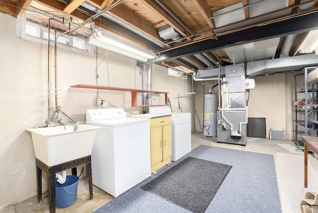 basement featuring gas water heater, a sink, washing machine and clothes dryer, and heating unit