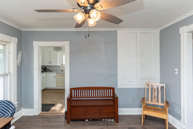 living area with a textured ceiling, baseboards, and wood finished floors