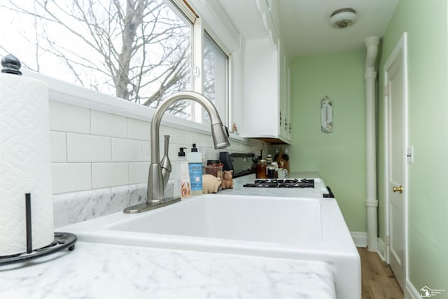 room details with white cabinets, light countertops, and a sink