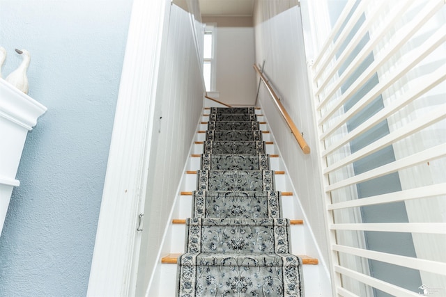 staircase featuring a textured wall