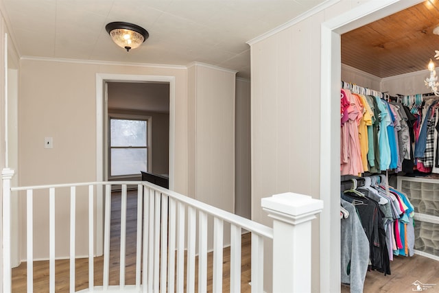 corridor featuring crown molding, an upstairs landing, and wood finished floors