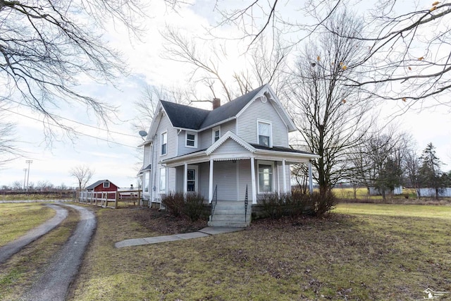 view of front of home featuring a chimney, a front lawn, and a porch