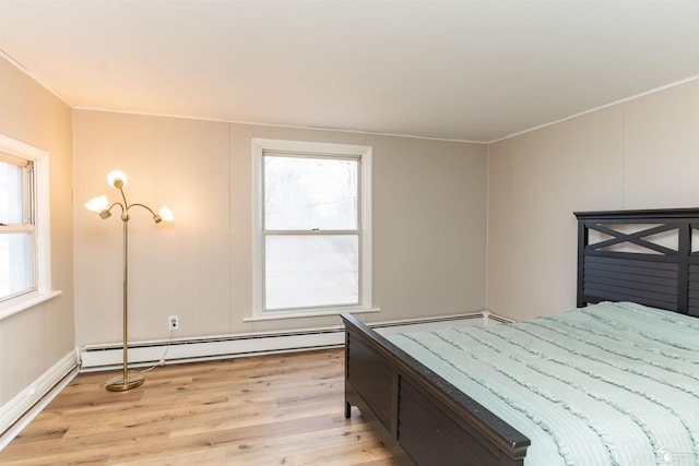 bedroom featuring a baseboard heating unit, a baseboard radiator, and light wood finished floors