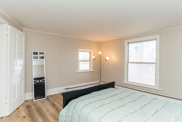 bedroom with a notable chandelier and light wood-style flooring