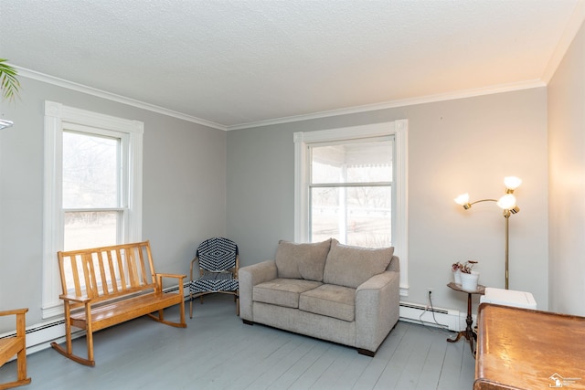 sitting room featuring a baseboard heating unit, light wood-type flooring, ornamental molding, and a textured ceiling