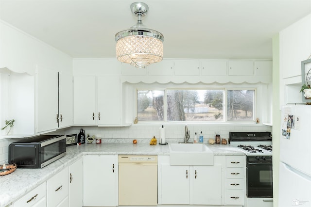 kitchen featuring tasteful backsplash, light countertops, white cabinetry, a sink, and white appliances