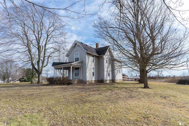 view of property exterior with a lawn and a chimney