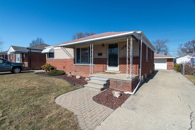 view of front facade with an outbuilding, a porch, a front lawn, a garage, and brick siding