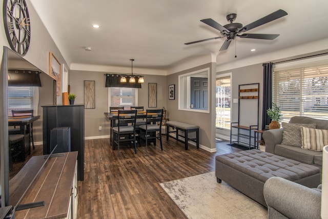 living area with recessed lighting, baseboards, dark wood-type flooring, and ceiling fan with notable chandelier