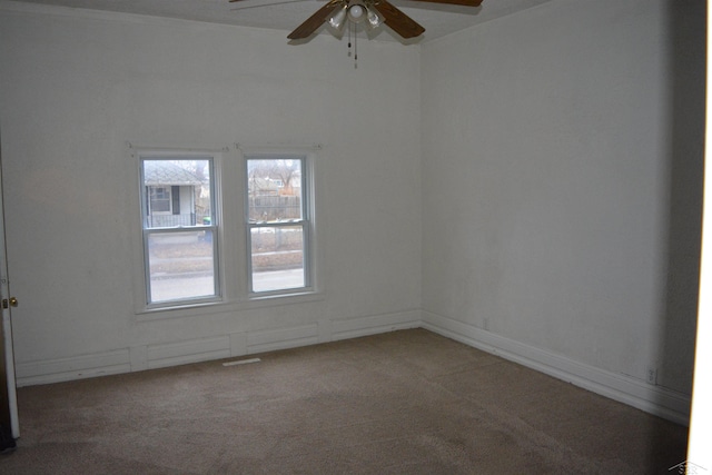 spare room featuring ceiling fan, baseboards, and carpet flooring