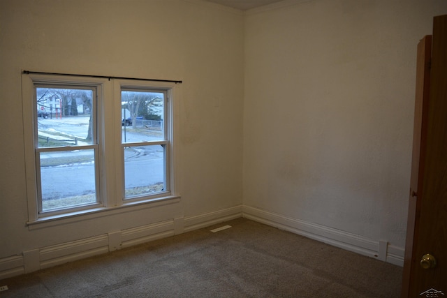 spare room featuring carpet floors, visible vents, and baseboards