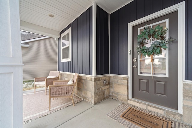 135 Barnsley Dr, Howell, MI 48843 - doorway to property featuring board and batten siding, stone siding, and a porch
