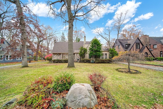 view of front of home featuring a chimney, a front yard, and a residential view