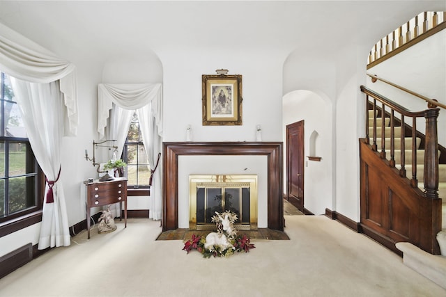 living room with carpet floors, a healthy amount of sunlight, and a fireplace with flush hearth