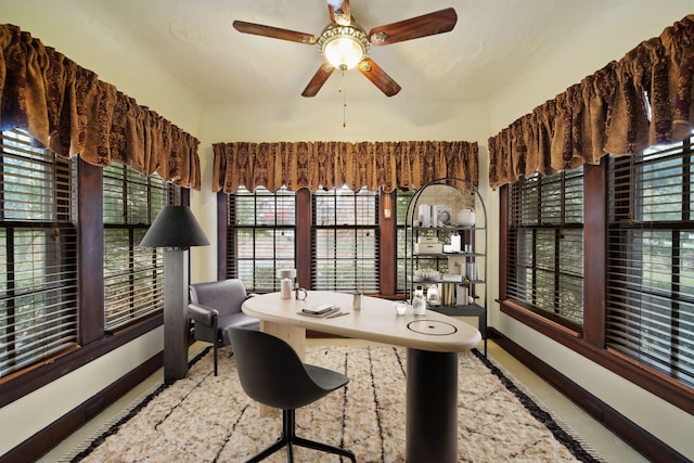 office area featuring a ceiling fan and baseboards