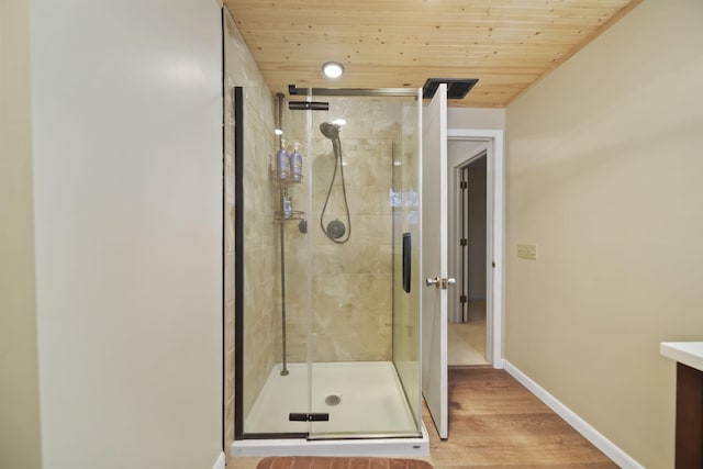 full bath featuring wood ceiling, vanity, baseboards, and a shower stall