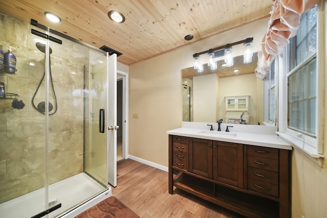 bathroom featuring wooden ceiling, wood finished floors, vanity, baseboards, and a stall shower