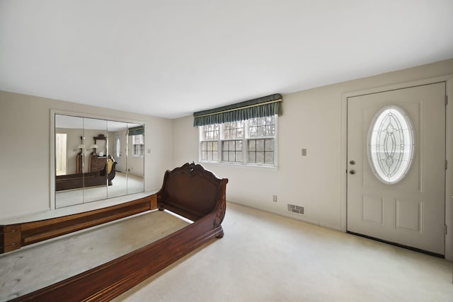 foyer entrance featuring carpet and visible vents